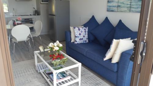 a blue couch in a living room with a table at Jake's Place Oneroa Waiheke in Oneroa
