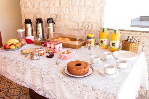 a table with a cake and other food on it at Casarao Hostel - Analandia SP in Analândia