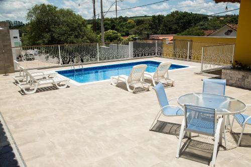 a patio with chairs and a table and a pool at Casarao Hostel - Analandia SP in Analândia