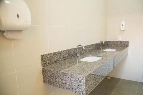 a bathroom with two sinks in a granite counter top at Casarao Hostel - Analandia SP in Analândia