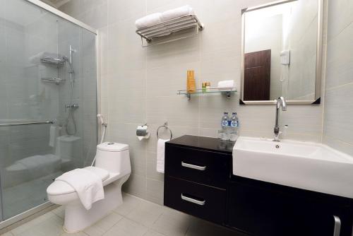 a bathroom with a toilet and a sink and a shower at Timor Plaza Hotel & Apartments in Dili
