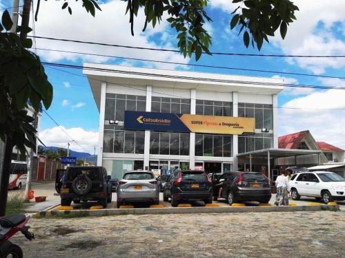 a parking lot with cars parked in front of a building at HOTEL ANAPOIMA PLAZA IN in Anapoima
