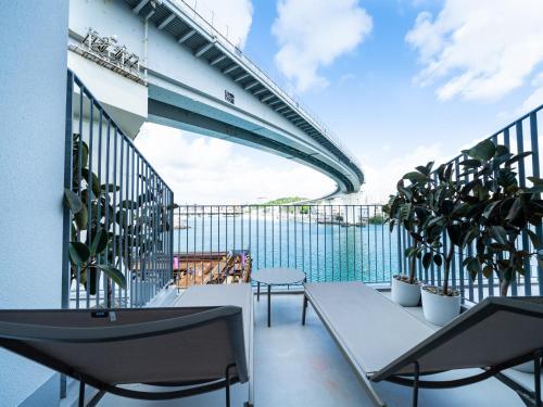 a balcony with a table and chairs and plants at HOTEL ANTEROOM NAHA in Naha