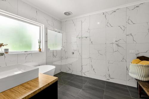 a white bathroom with a tub and a sink at Tuscan style ocean beach escape on the Peninsula only 400m to beach in Saint Andrews Beach