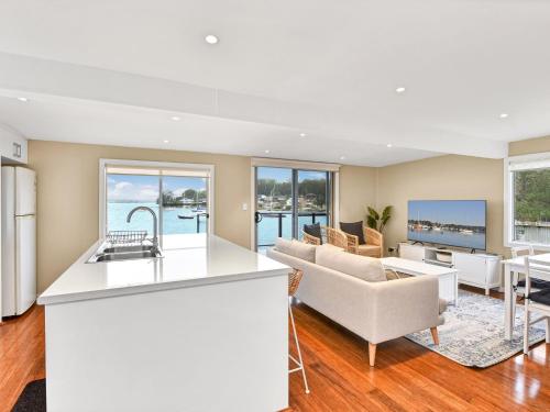 a kitchen and living room with a couch and a table at The Boat House Absolute Waterfront and Jetty in Morisset East