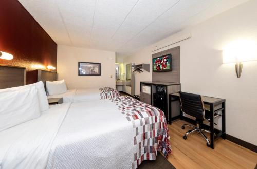a hotel room with a bed and a desk at Red Roof Inn Edison in Edison