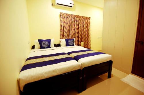 a bedroom with a large bed with blue and white sheets at Geo Fort Home - Fortkochi in Fort Kochi