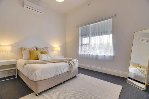 A bed or beds in a room at Beach & Pines Glenelg