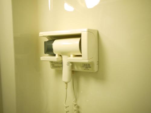 a phone on a wall with a cord plugged into it at Hotel Route-Inn Tsu Ekiminami -Kokudo23gou- in Tsu
