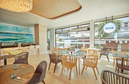 un restaurante con mesas y sillas y una gran ventana en Pattaya Sea View Hotel - SHA Extra Plus, en Pattaya central