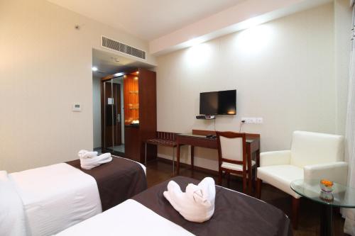 a hotel room with two beds and a desk at BEST WESTERN TIRUPATI in Chittoor