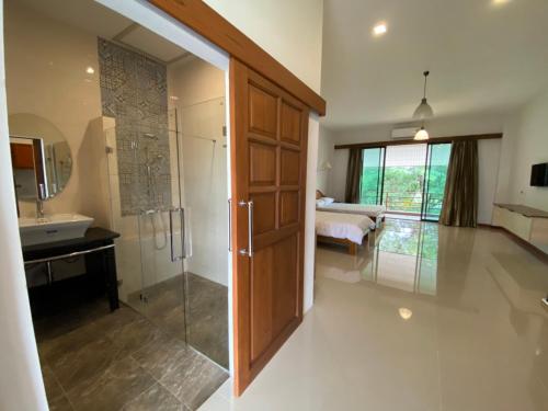 a bathroom with a shower and a toilet and a sink at Damnoen Care Resort in Damnoen Saduak