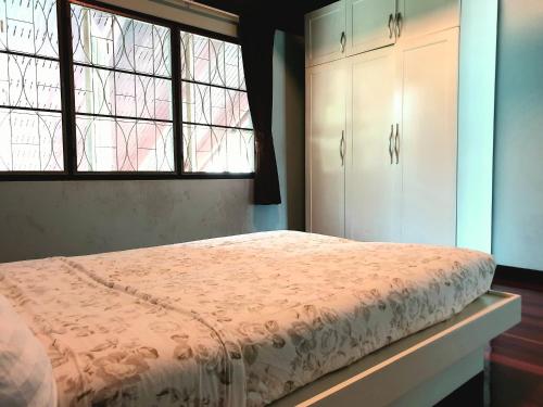 a bedroom with a bed and a window at โรงแรม ชาโตว์วิสต้า in Chon Buri