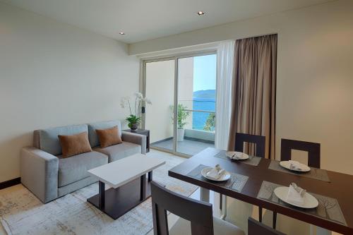 a living room with a couch and a dining room table at The Costa Nha Trang Residences in Nha Trang