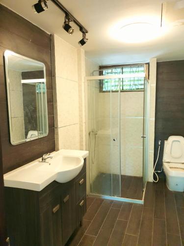 a bathroom with a sink and a glass shower at โรงแรม ชาโตว์วิสต้า in Chon Buri