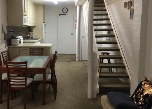 een keuken en eetkamer met een trap in een huis bij Hima 8 in Mount Buller