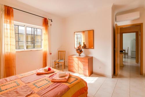 a bedroom with a bed and a dresser and a mirror at Bosque São José Af in Albufeira