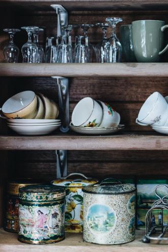 a shelf with plates and dishes on it at The Main House @ Poets Lodge in Daylesford