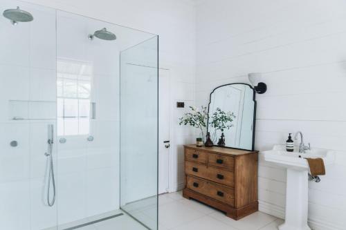 a bathroom with a shower and a sink and a mirror at The Main House @ Poets Lodge in Daylesford