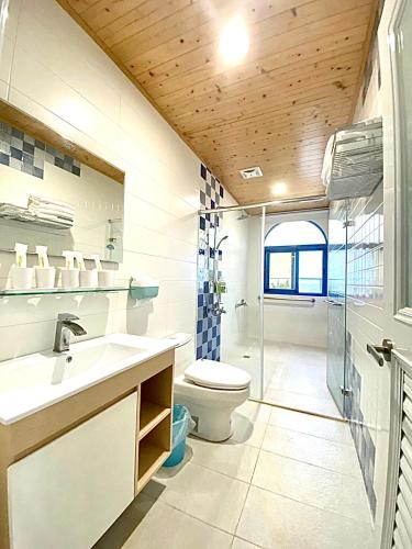 a bathroom with a toilet and a sink at Moon Bay Coastal Hotel in Xincheng