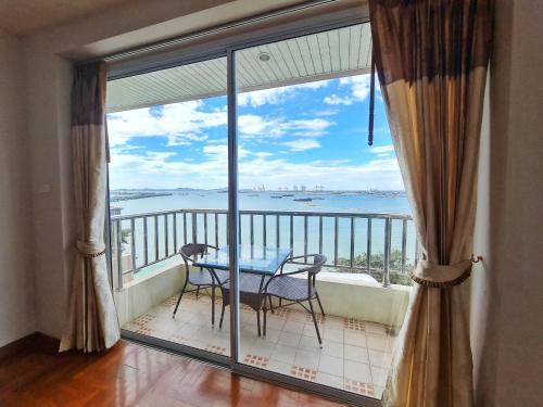 a balcony with a table and a view of the water at โรงแรม ชาโตว์วิสต้า in Chon Buri