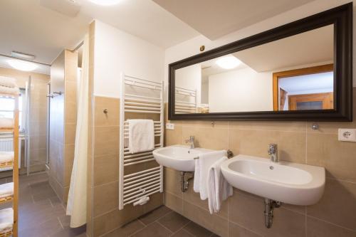 a bathroom with two sinks and a large mirror at WÄLDER: Quartier Dachsberg in Dachsberg im Schwarzwald