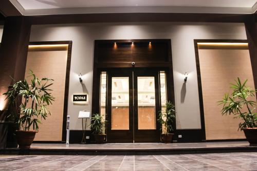 a front door of a building with potted plants at HOTEL RAJHANS ABHINANDAN in Bhopal