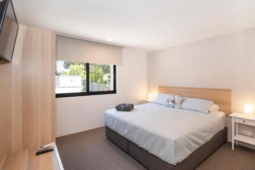 a bedroom with a bed and a window and a television at The Tipsy Grape Downtown, Margaret River in Margaret River Town