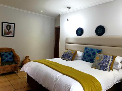 a bedroom with a bed with two clocks on the wall at Damicha Boutique Lodge in Ezulwini