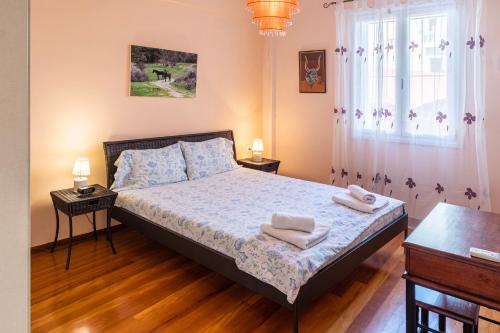 ein Schlafzimmer mit einem Bett mit zwei Handtüchern darauf in der Unterkunft Erika's Oasis - Stylish Gem inthe Heart of History in Kalamata