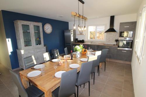 a dining room with a large wooden table and chairs at Gite LES BOUCHES ROUGES avec piscine privée in Vesseaux