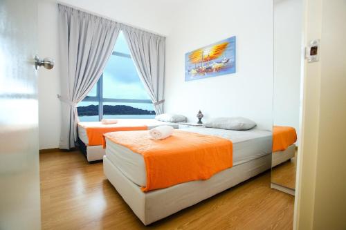 dwa łóżka w pokoju z oknem w obiekcie NASA Family Suite at Imperium Residence w mieście Kuantan