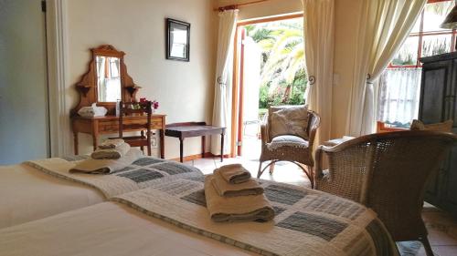 a bedroom with a bed with towels on it at Saxe-Coburg Lodge in Prince Albert