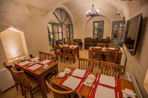 a restaurant with tables and chairs in a room at Sinasos Star Hotel in Ürgüp