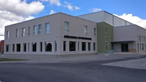 a large white building with a sign on it at Märjamaa spordihoone in Märjamaa