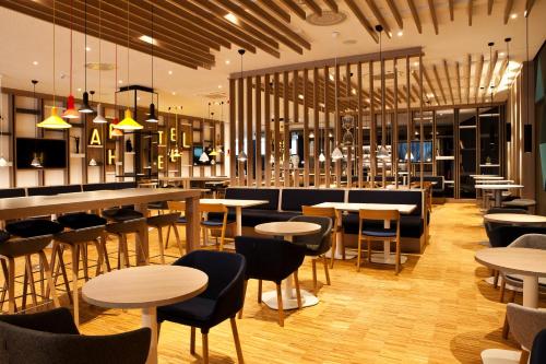 a restaurant with tables and chairs and a bar at Holiday Inn Express - Göppingen by IHG in Göppingen