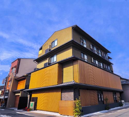 ein gelbes und braunes Gebäude auf einer Straße in der Unterkunft HIZ HOTEL Kyoto-Nijo Castle in Kyoto