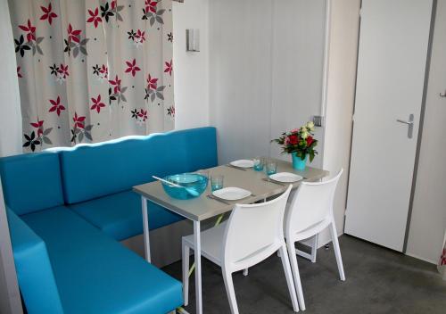 Chaillé-les-MaraisCamping l'île Cariot的餐厅里有一张桌子和几把椅子