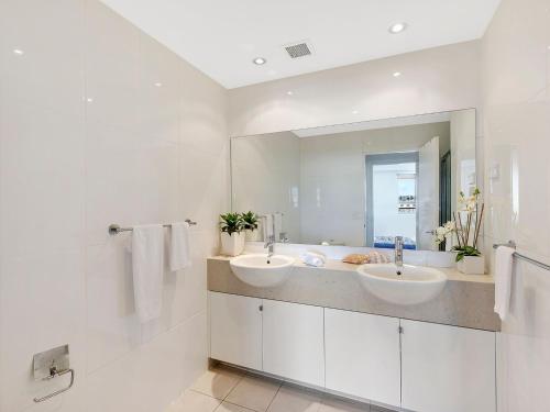 a white bathroom with two sinks and a mirror at Blue Coral Terrace Coast Luxury 31 in The Entrance