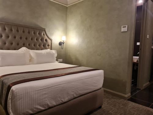 a bedroom with a large bed with a large headboard at 1969 Business Suites @ Ipoh Garden in Ipoh