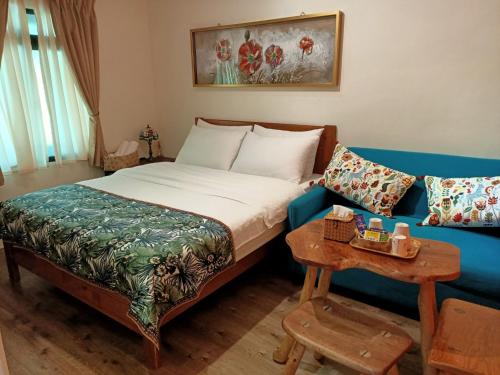 a hotel room with a bed and a couch at Jilufugan B&B in Taimali