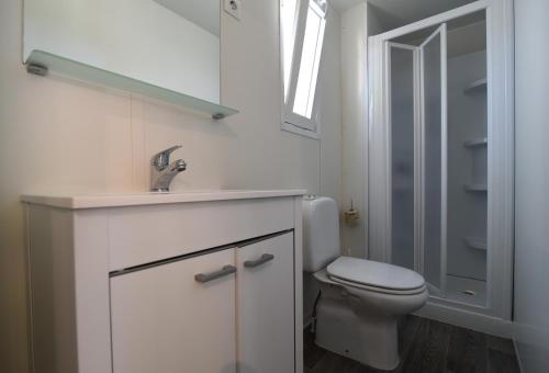 bagno con servizi igienici, lavandino e specchio di International Family Camping Village Riccione a Riccione