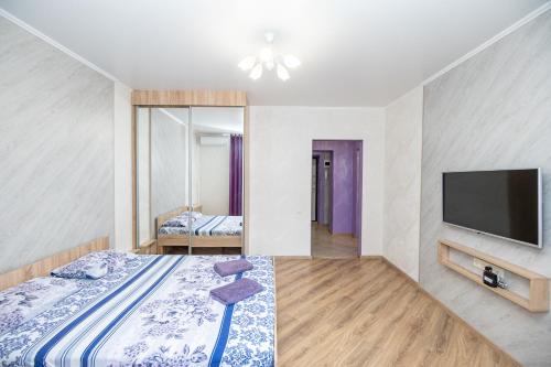 1 dormitorio con 1 cama y TV de pantalla plana en Apartment on Chistopolskaya 66 en Kazán