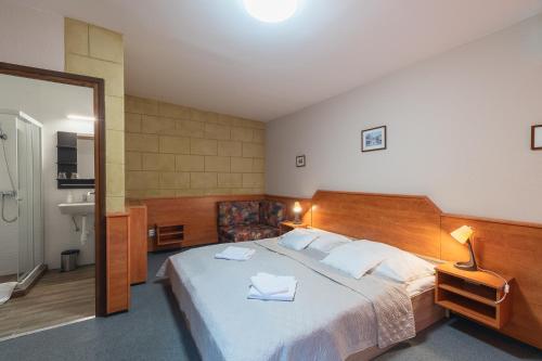 a bedroom with a large bed and a bathroom at Delanta Panzio in Pécs