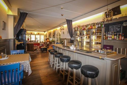 eine Bar mit einer Reihe von Hockern in einem Restaurant in der Unterkunft Hotel 1900 in Bergen