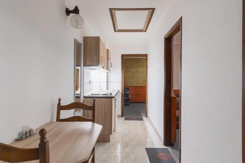 a kitchen with a wooden table and a dining room at Delanta Panzio in Pécs