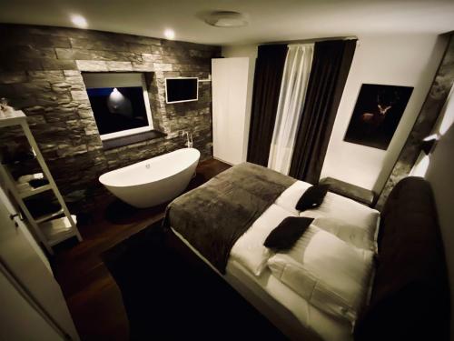 a bathroom with a bed and a bath tub and a sink at TRENDY HOUSE 193 in Mátranovák