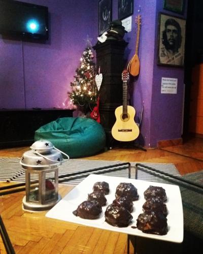 a table with a tray of chocolate donuts and a guitar at HostelChe Hostel in Belgrade