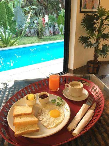 HALF Hotel, Calangute في كالانغيُت: طبق الإفطار مع البيض والخبز المحمص على الطاولة