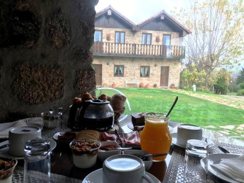 una mesa con comida y una olla de zumo de naranja en Villa Silene, en Covilhã